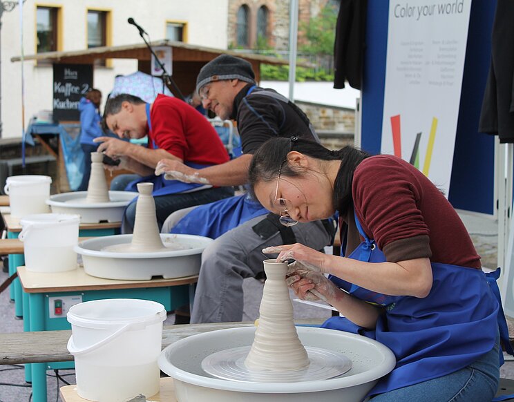 Höhr-Grenzhausen Töpfermeisterschaft Mehrere Personen arbeiten an Töpferscheiben