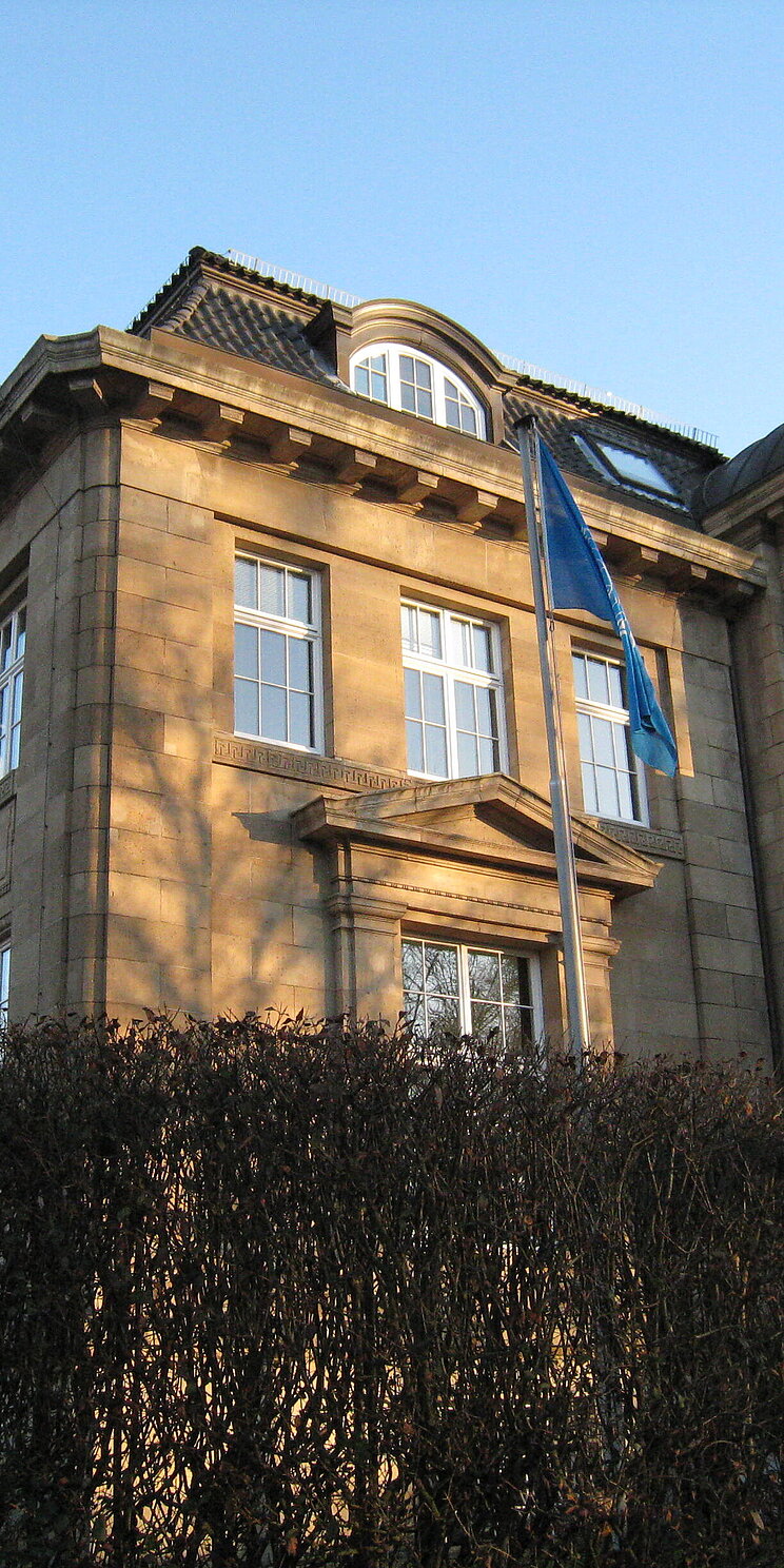 Eine Villa mit Fahnen vor blauem Himmel: Der Dienstsitz des UIL in Hamburg