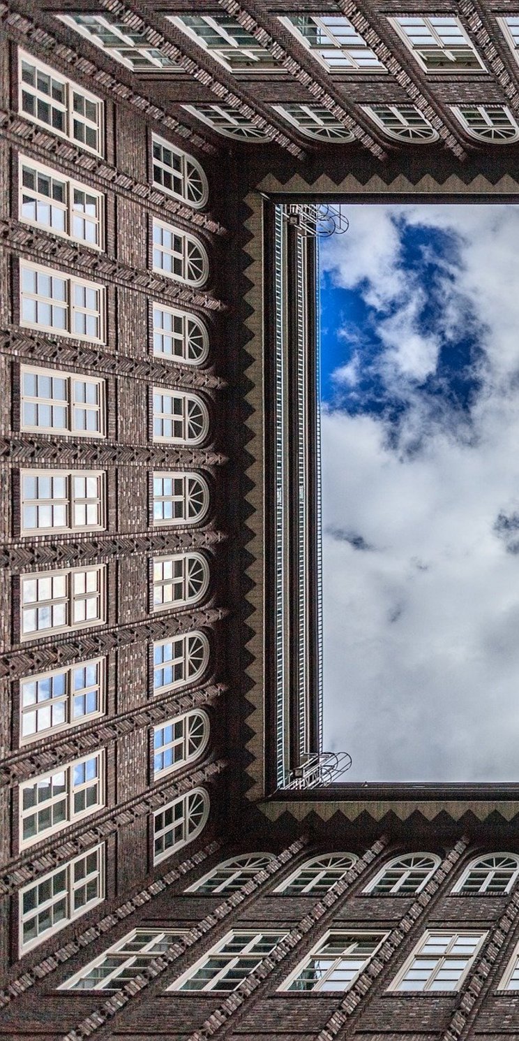 Blick in den Himmel entlang der Fassaden des Innenhofes des Chilehauses in Hamburg