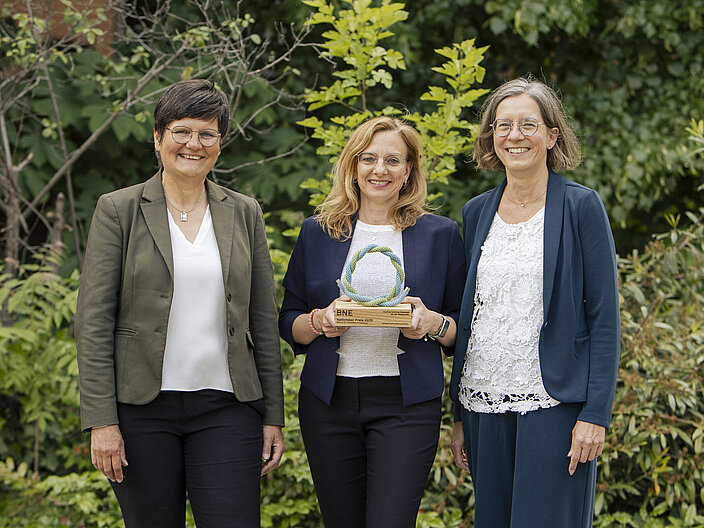 BNE-Preisträgerinnen_2025 Foto von drei BNE-Preisträgerinnen mit Trophäe