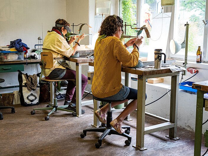 Zwei Teilnehmerinnen der Internationalen Sommerakademie des Bild-Werk Frauenau bei der Arbeit am Gravurbock