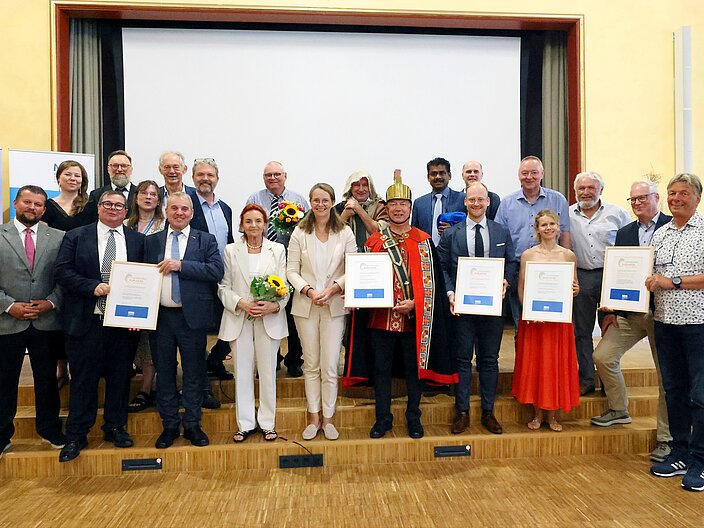 Alle Tr&auml;gergruppen und Beteiligten auf der B&uuml;hne mit ihren Urkunden