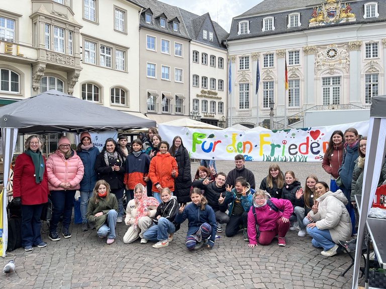 Nelson-Mandela_Projektschule Schülerinnen und Schüler mit einem Plakat, auf dem "Für den Frieden steht"