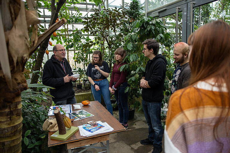 Auf diesem Foto sind Studierende und ein Professor der Universit&auml;t W&uuml;rzburg bei einem Kurs im Gew&auml;chshaus zu sehen. 