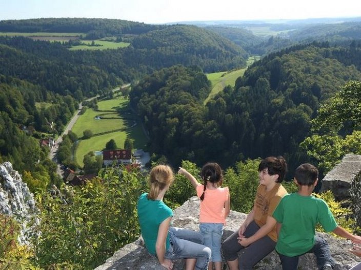 Wandergruppe über bewaldeter Gebirgslandschaft
