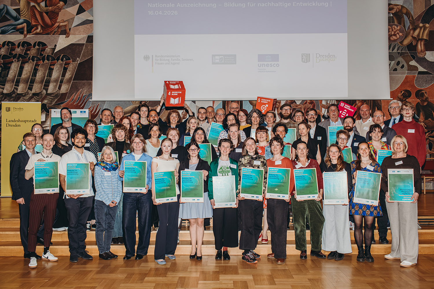 Die Gruppe von 31 Ausgezeichneten stehen gemeinsam vor der B&uuml;hne