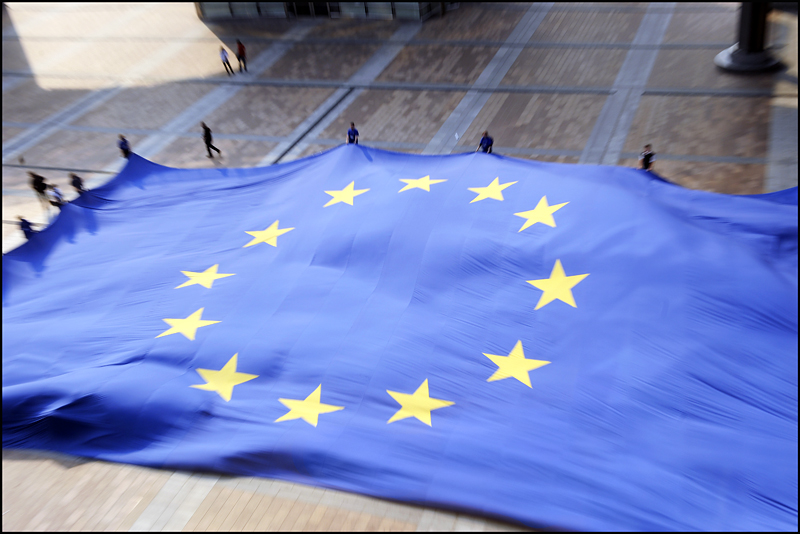 Europaflagge Viele Menschen spannen auf einem Platz eine übergroße Europaflagge auf.