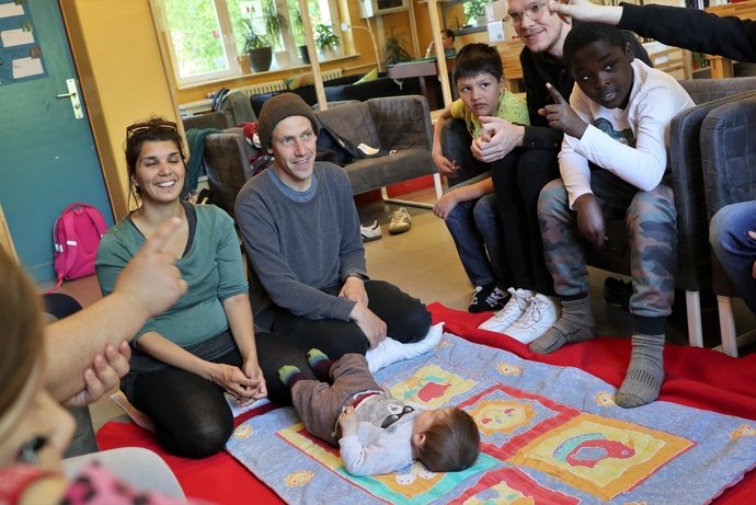 Schüler sitzen um ein Baby