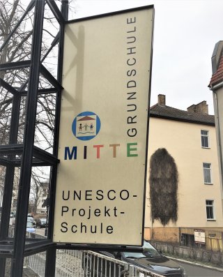 Schild mit der Aufschrift "UNESCO-Projekt-Schule" auf dem Schulhof 