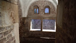 Das innere der Speyerer Mikwe, ein Steinbau mit Bögen und Fenstern.