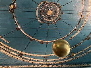 Blau goldene Decke des Planetariums. In der Mitte ist ein goldener Planet befestigt. 