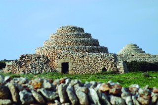 Zwei kegelförmige Steinbauten mit eine rechteckigen Eingang. 