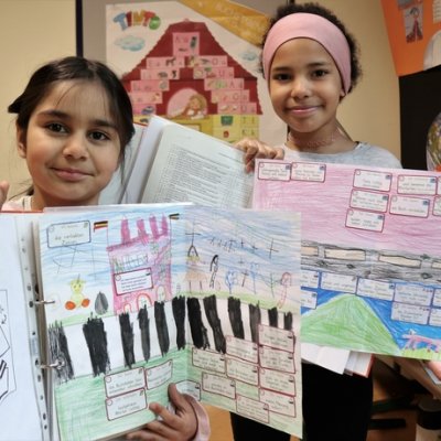 Zwei Mädchen zeigen ihre selbst gemalten Lernpläne