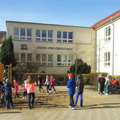 Jugendliche spielen vor dem Schulgebäude 