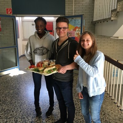 Drei Jugendliche verteilen Essen 