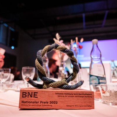Die Trophäe des BNE-Preises 2022 steht auf einem Tisch. Die Trophäe ist aus einem Stück Kletterseil gefertigt.